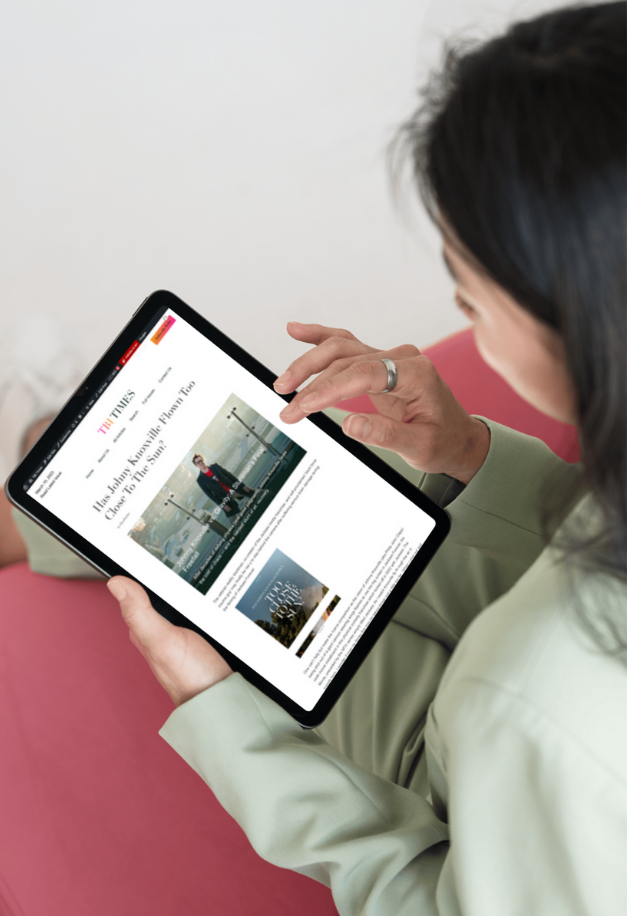 An image of a woman reading a TBI times article on her ipad